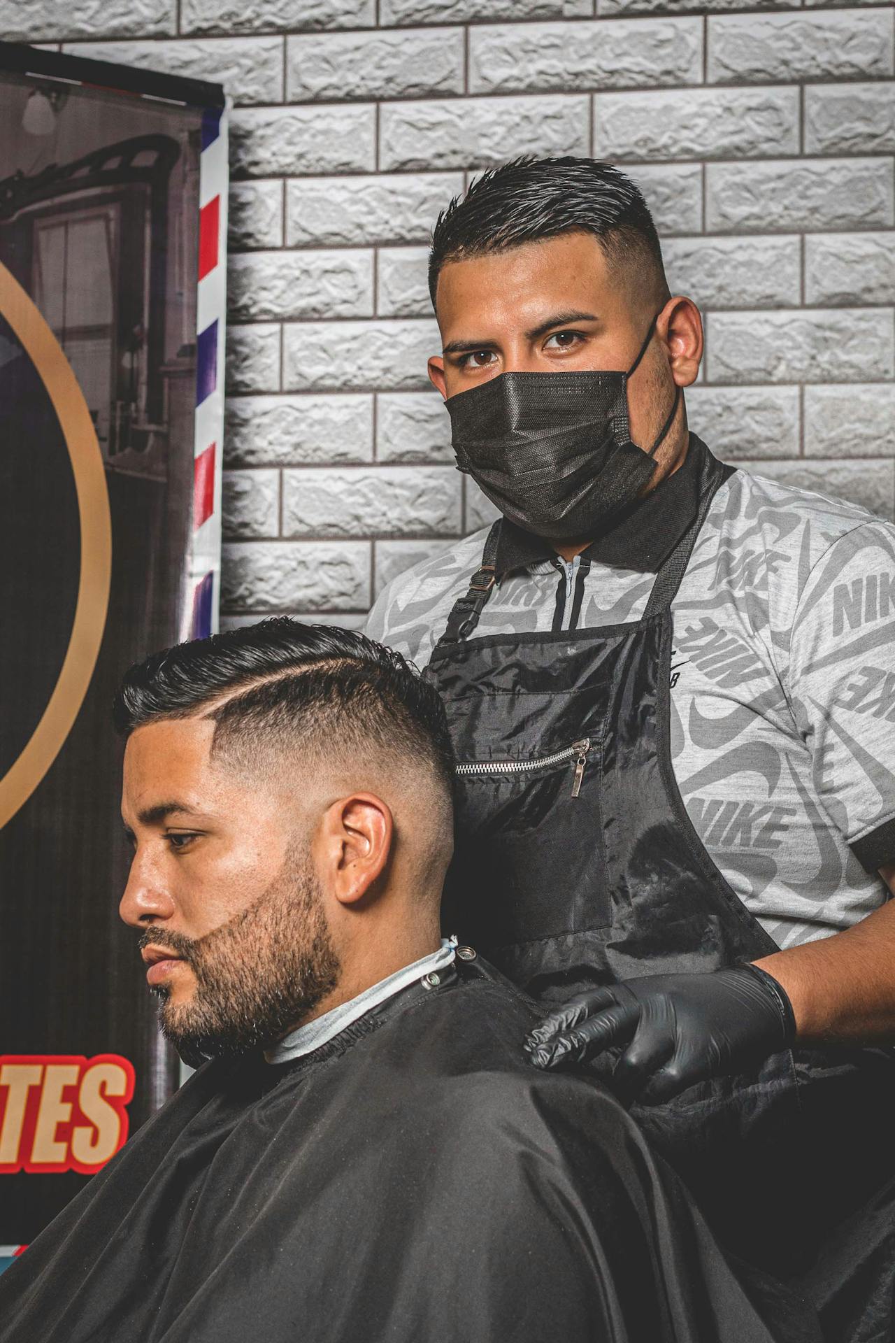 A senior barber team portrait inside the shop.