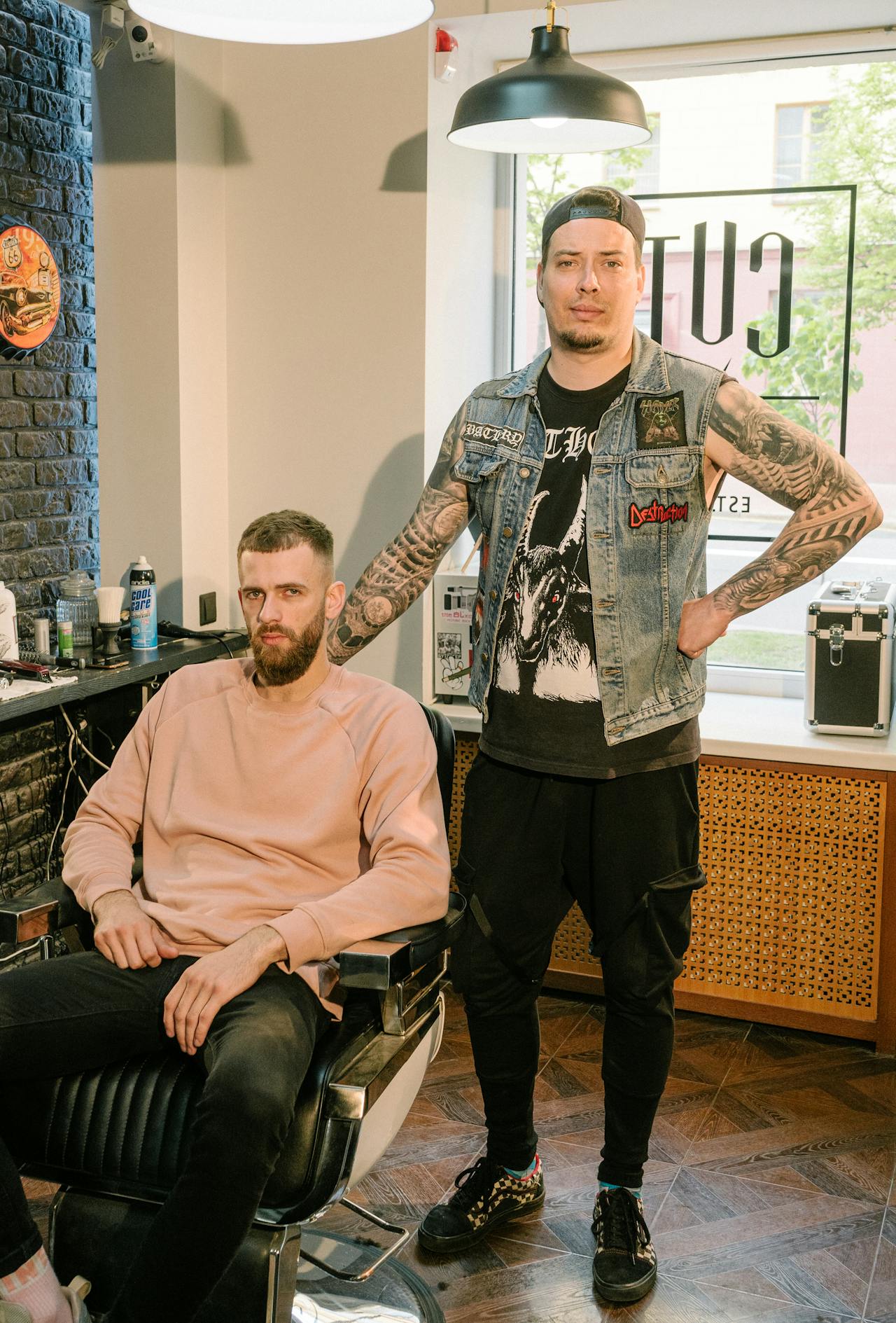 A senior barber standing behind a client after a finished cut.