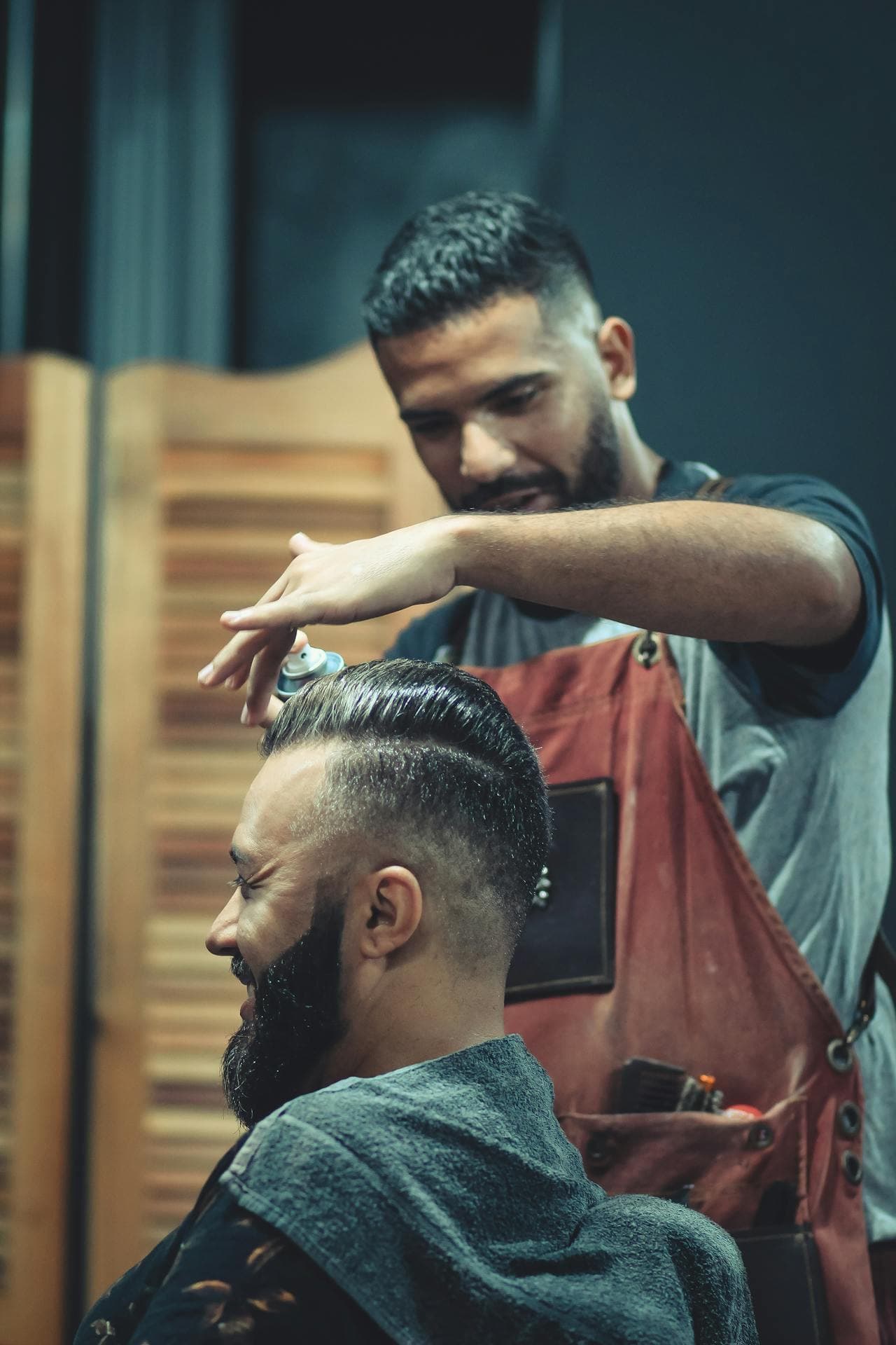 Barber using scissors to reshape longer hair with controlled movement.