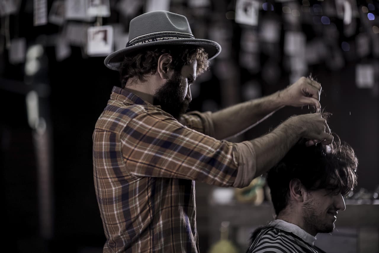 Barber cleaning the fade at the back of the head.