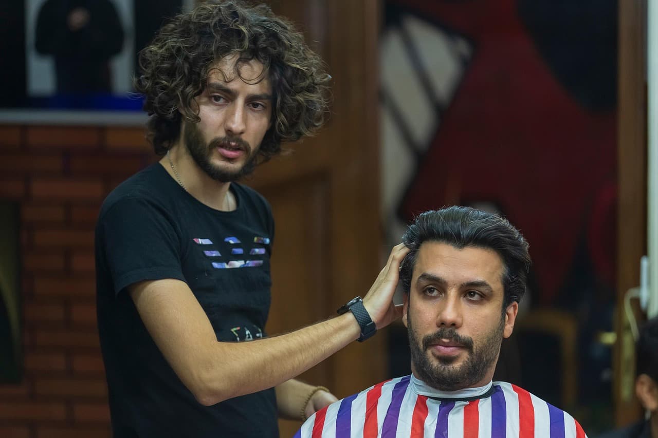 Barber and client framed in the mirror.
