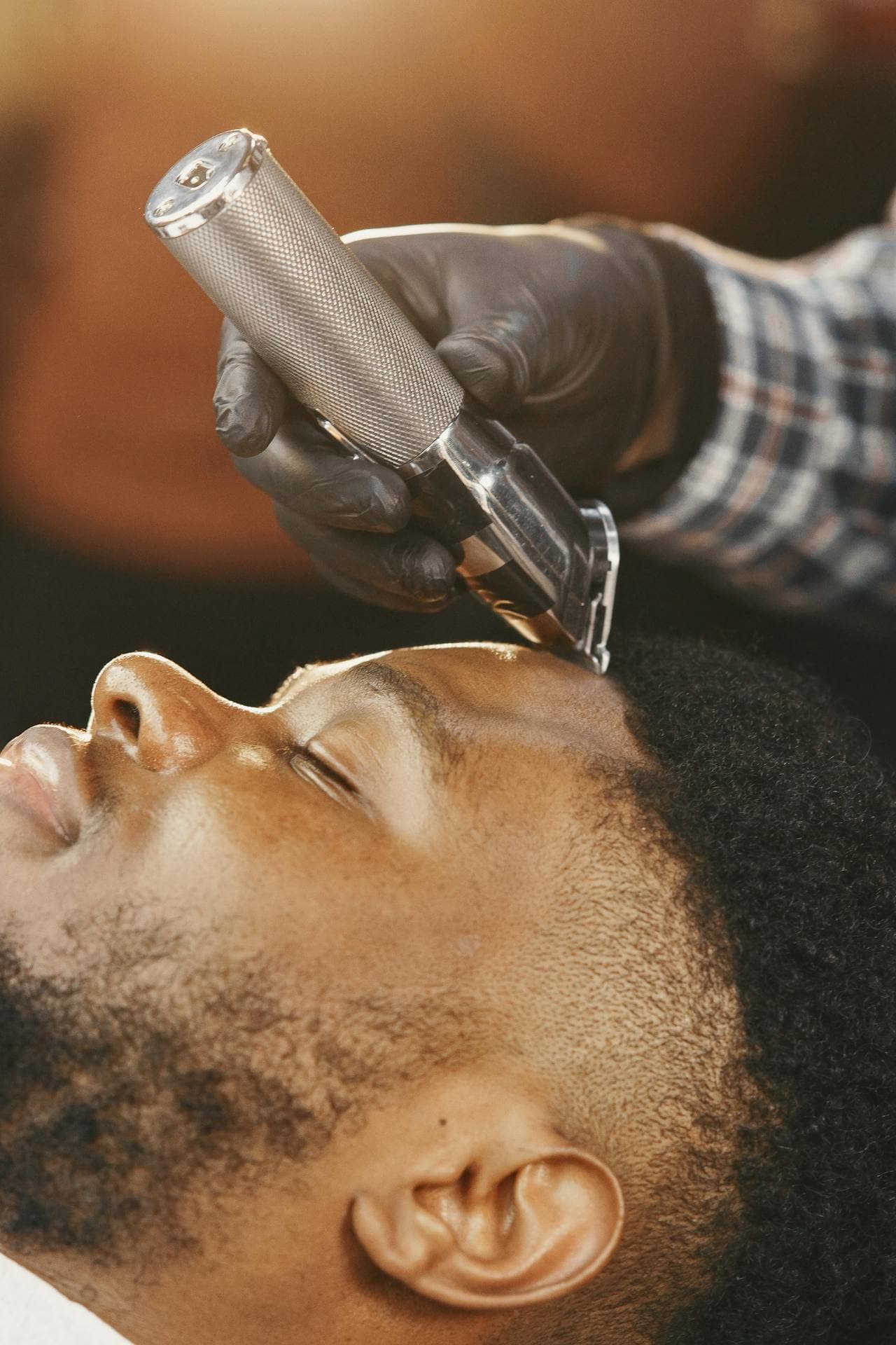 Barber trimming around the temple with scissors.