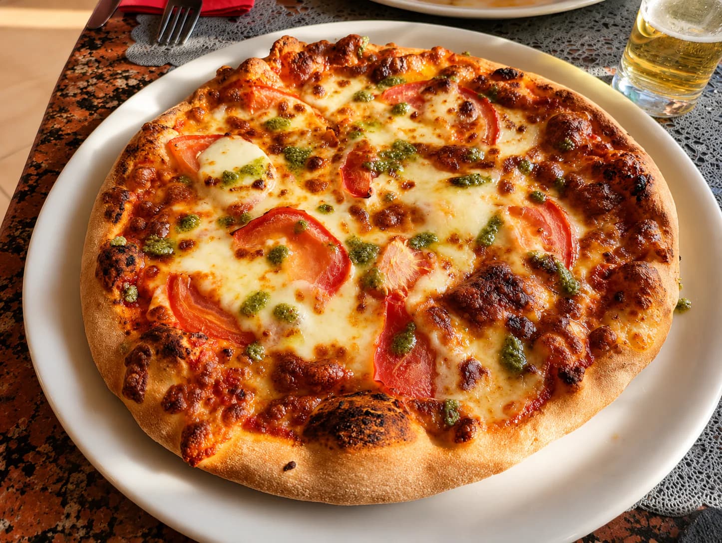 Pizza met tomaat, mozzarella en pesto