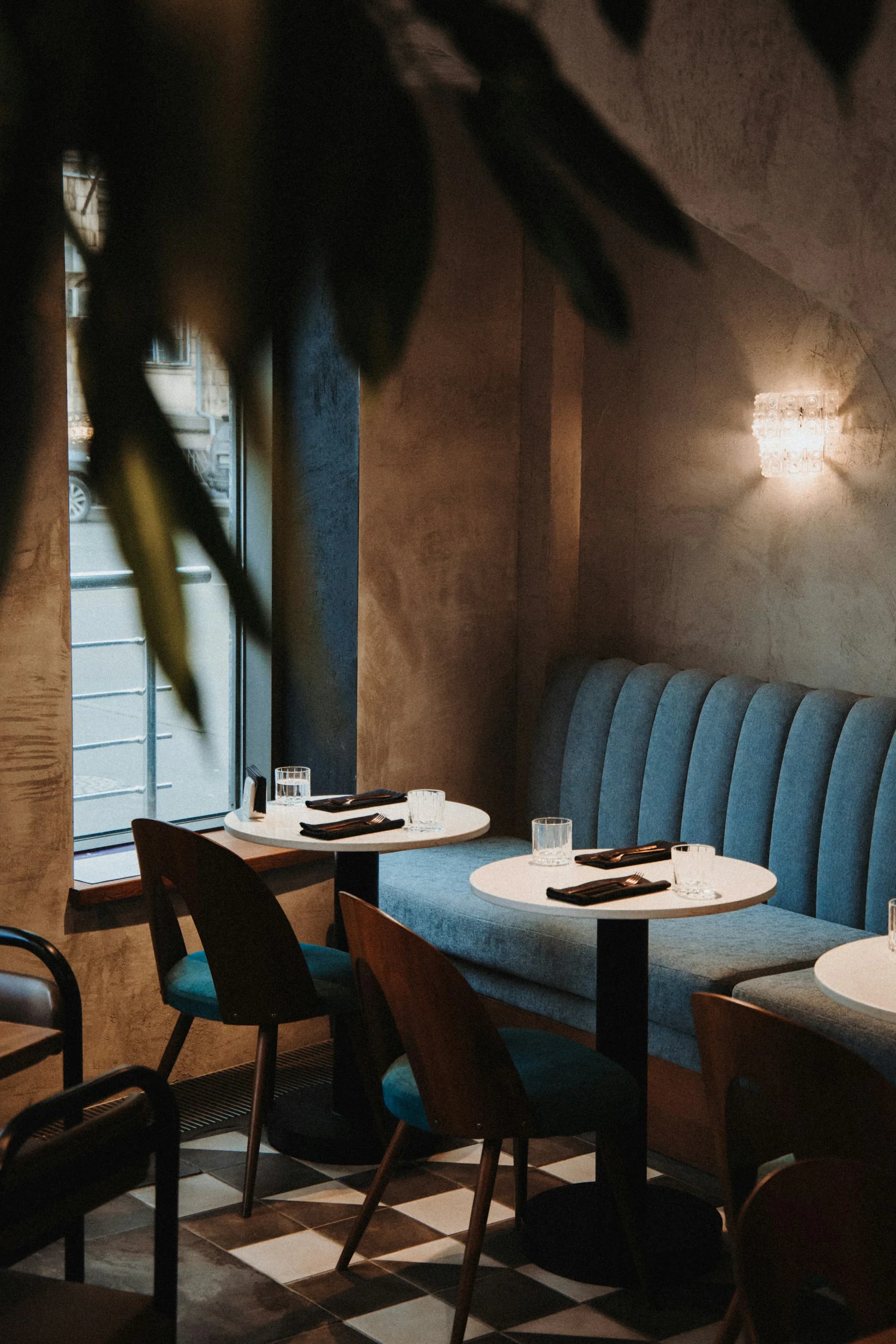 An intimate restaurant table beside a blue banquette