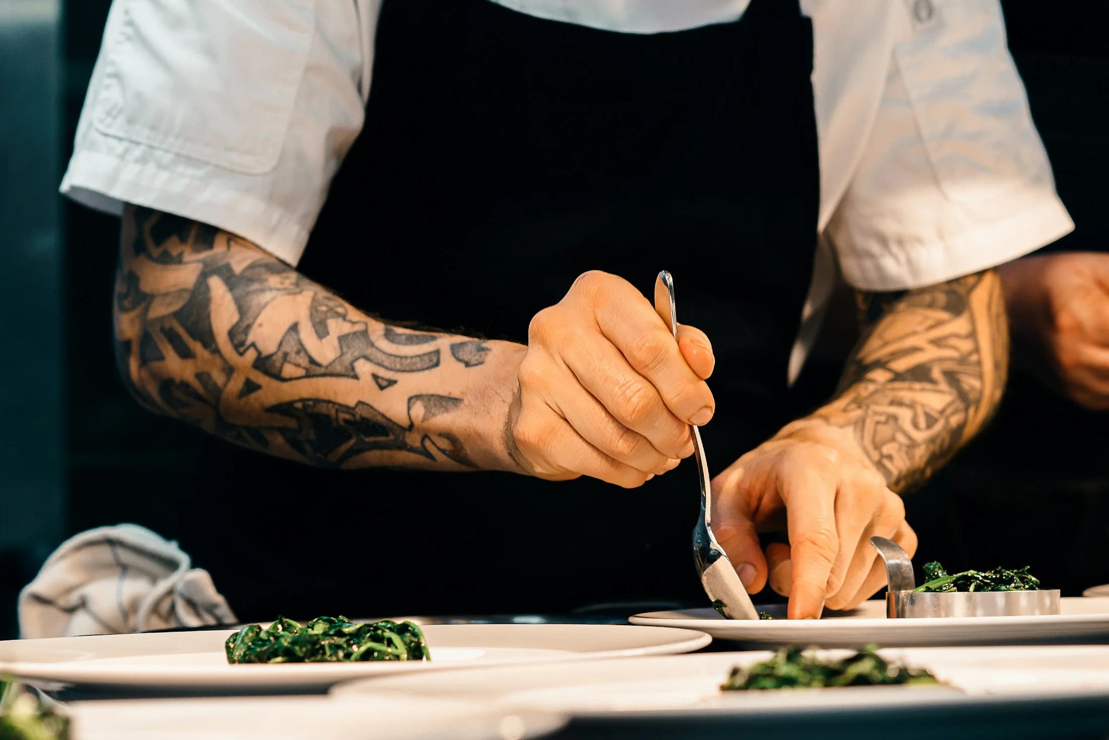 A cook adding the final detail to a plate