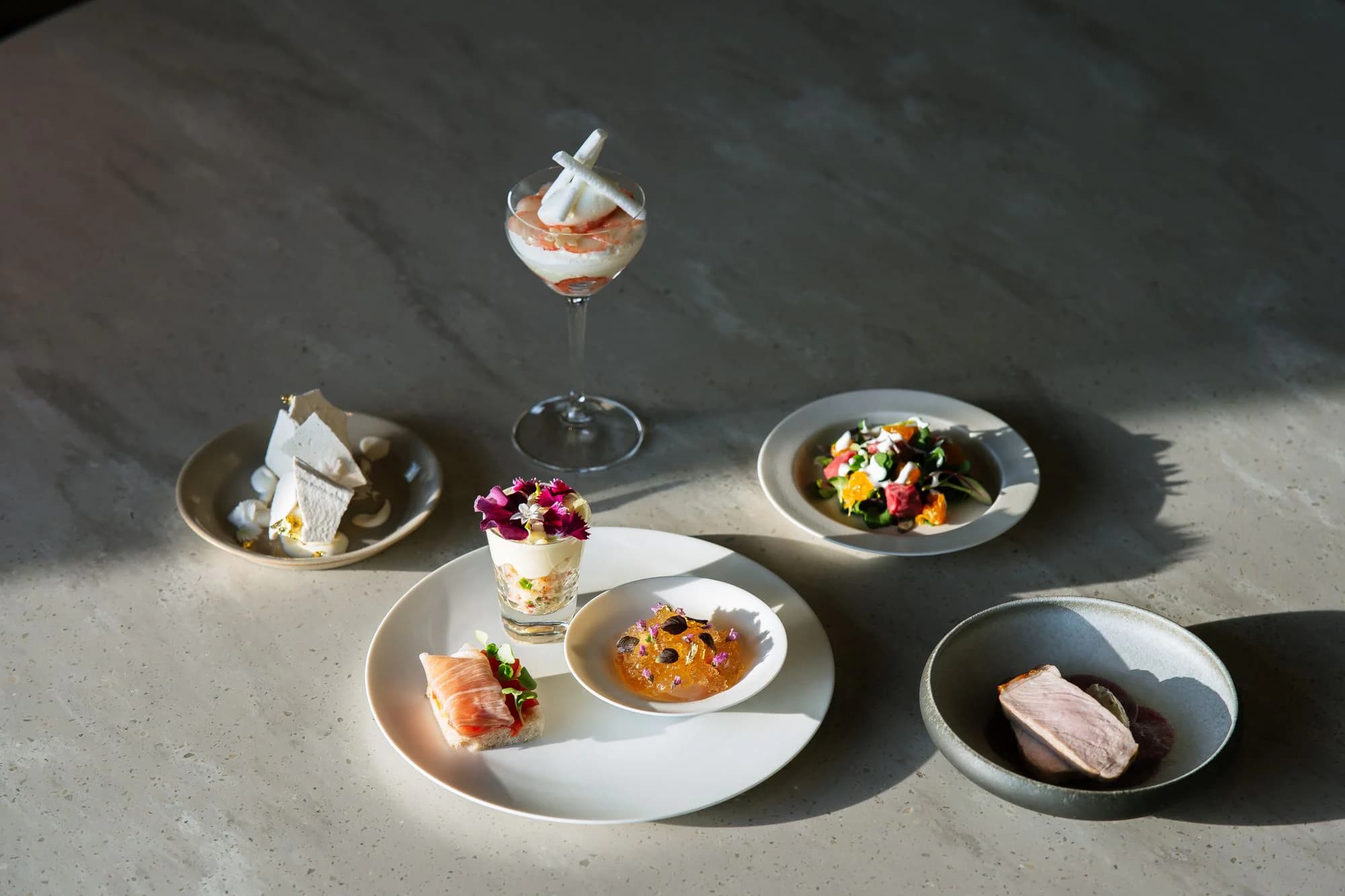 A seasonal tasting menu arranged across pale ceramic plates