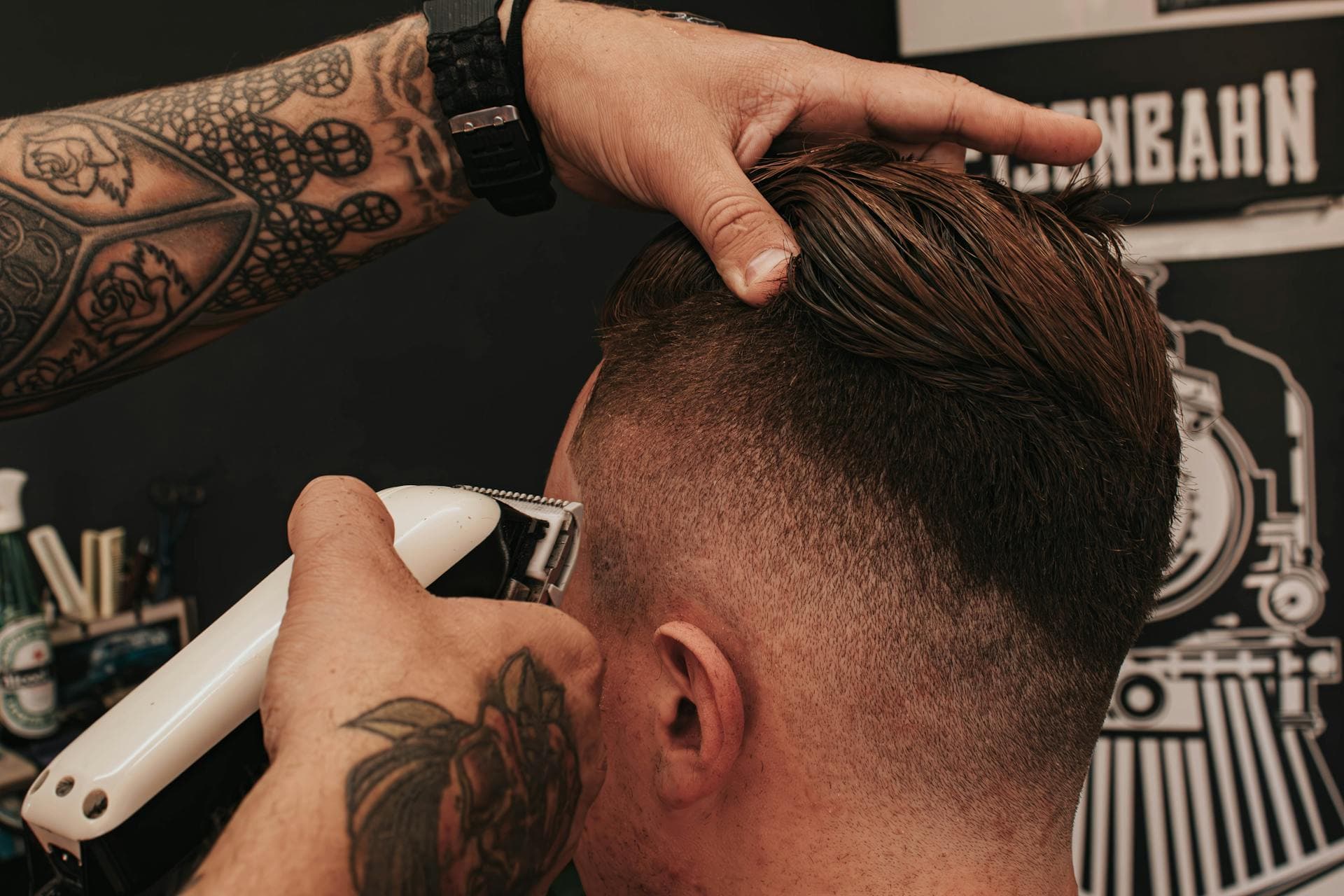 Close-up of a barber shaping a fade with clippers.